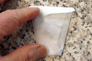 Folded filter paper envelope containing seeds.